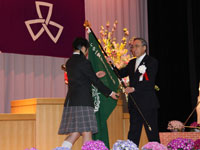 新しい校章旗を受け取る代表生徒