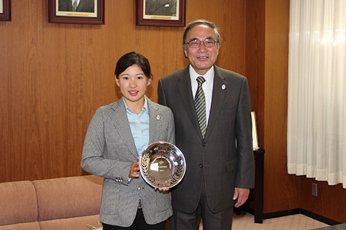 永井さんは日本女子オープンで受賞したベストアマチュアの銀皿を手に区長と記念撮影