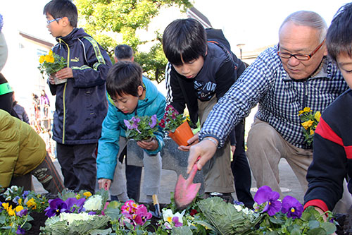 地域の方と花を植える児童
