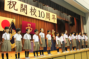 壇上で記念合唱する児童生徒