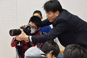 スポーツ記者の仕事道具カメラを覗く子ども
