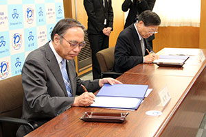 協定書に署名する濱野区長と小口理事長