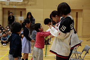 児童から首飾りとメダルを受ける選手