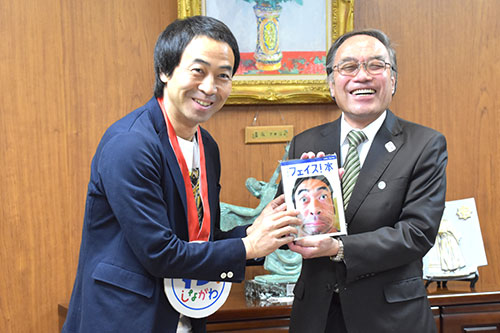 区長に写真集を手渡すワッキーさん