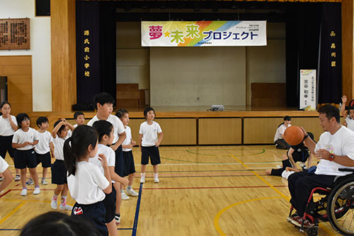 バスケットボールを手に子どもたちに語り掛ける京谷さん