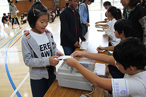 投票用紙を受け取る児童