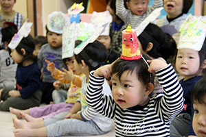 乳児のクラスではカラフルな紙をコップに詰めてお面を作成