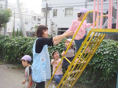 写真:1日保育士体験 滑り台で遊ぶ様子