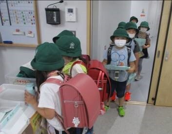 学校が終わり、すまいるスクールで受付をしている写真