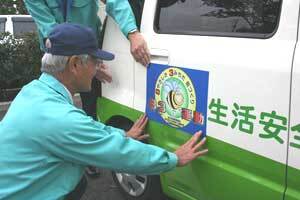 写真:83運動ステッカーを自動車に貼っている様子