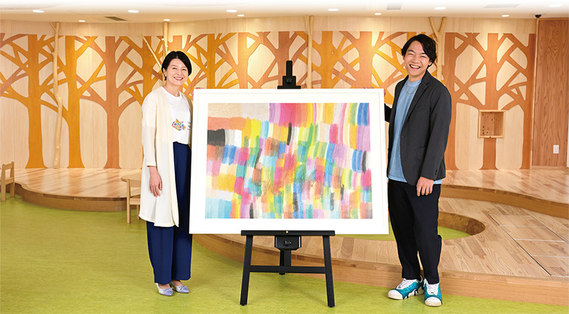 写真：アート原画と並ぶ森澤区長と伊沢さん