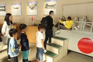 写真:飛行機の模型に座る様子