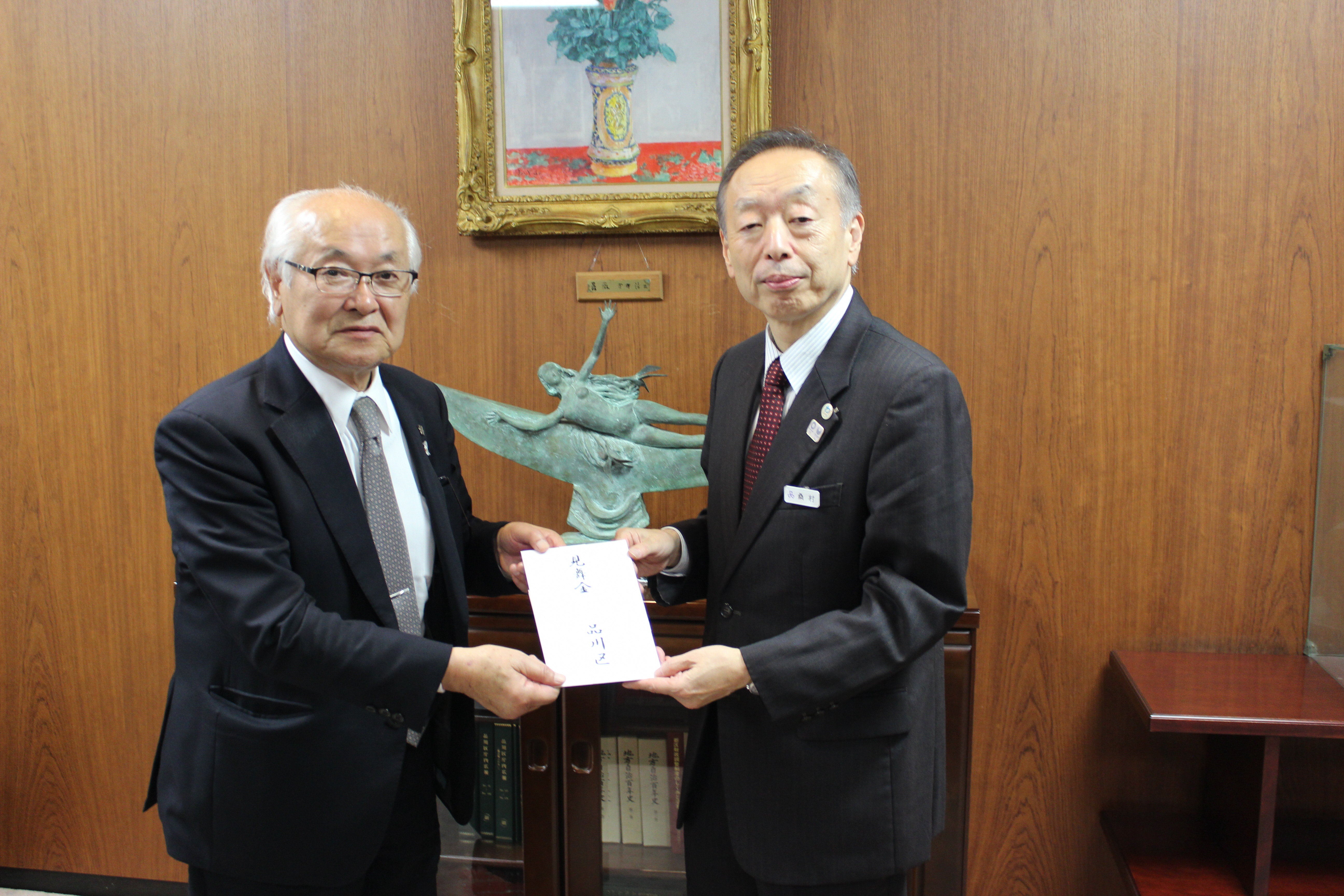 見舞金を手渡す様子（左側　辻󠄀 一幸 町長）