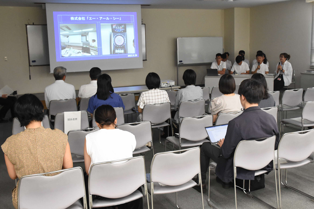 会場でスクリーンを使用して発表している様子の写真