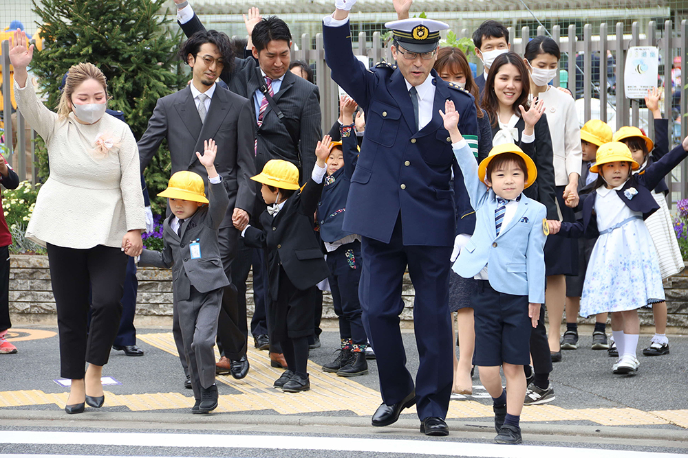 子どもと一緒に横断歩道を渡る警視総監