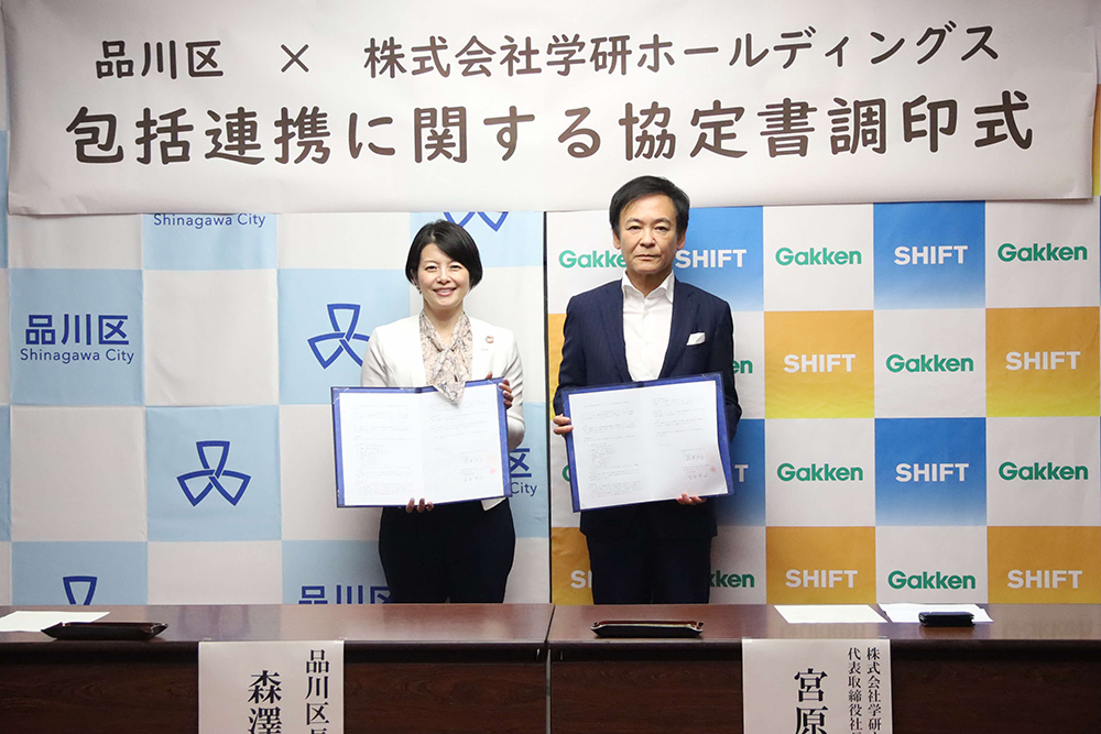 協定書を持って写真撮影する森澤区長と宮原代表取締役の画像