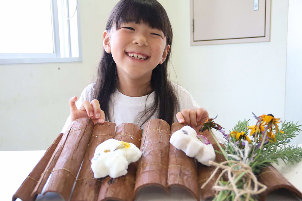 完成した石鹸を持って笑顔になる子どもの画像