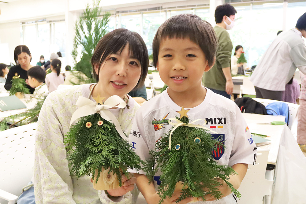 オリジナルツリーを持って写真を撮る親子の画像