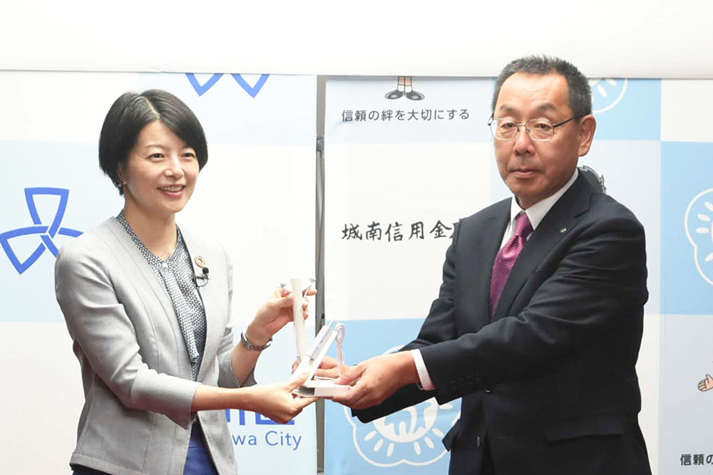 林理事から森澤区長へイヤホンが贈呈される画像
