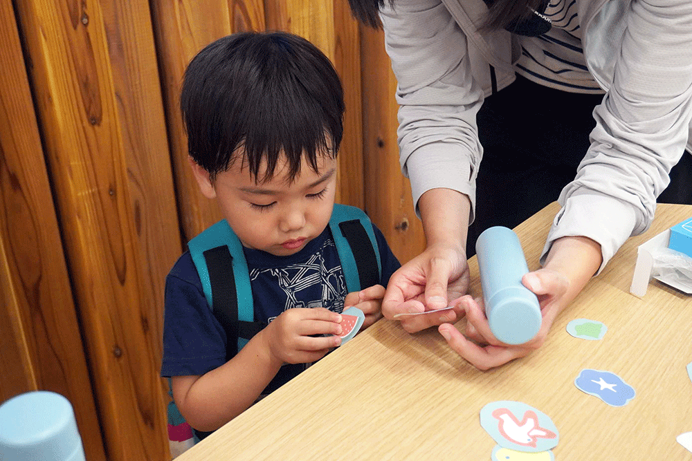 子どもが水筒に装飾している写真