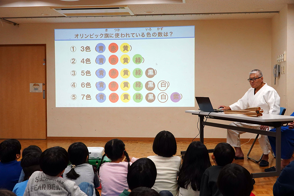 オリンピアンが子どもたちに説明している写真