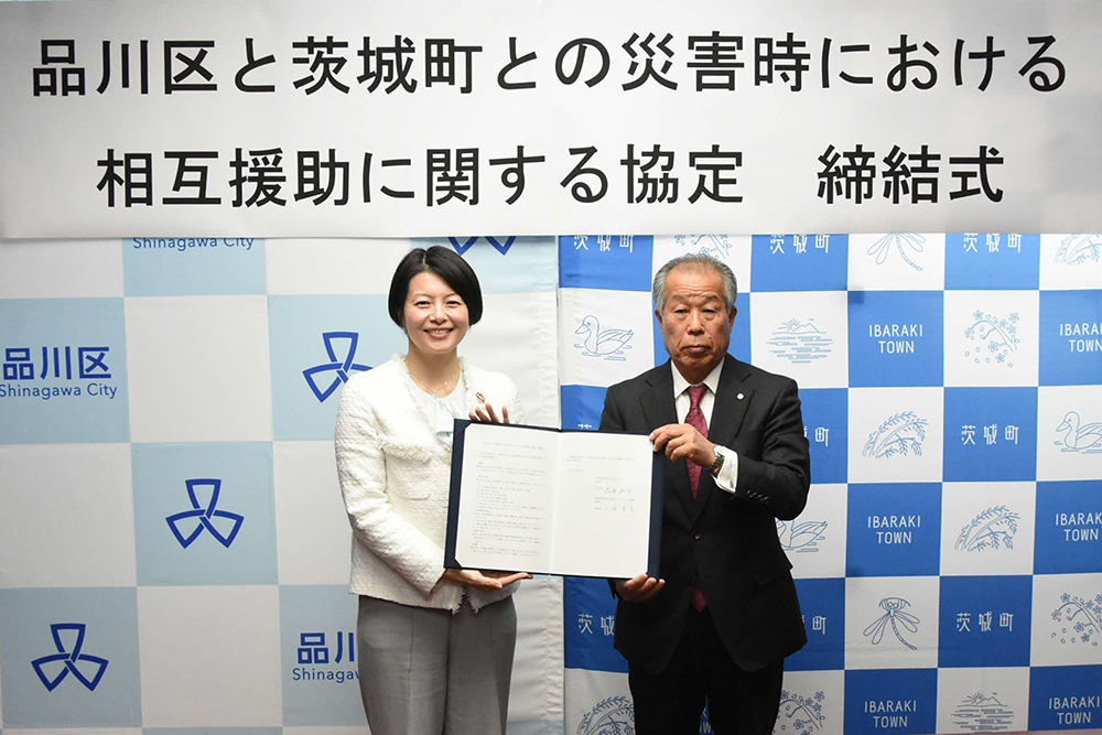 協定書を持ち記念撮影をする森澤区長と小林町長の画像