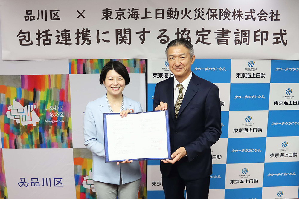 協定書を持って写真撮影に臨む森澤区長と東京海上日動火災の渡部執行役員