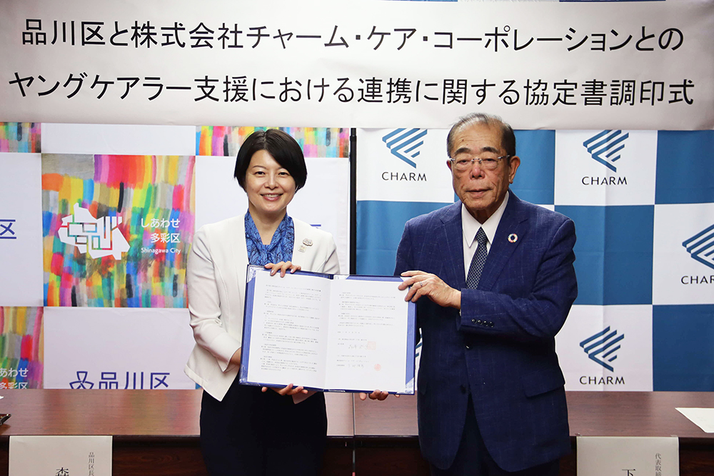 協定書を持って写真撮影に臨む森澤区長と下村チャーム・ケア・コーポレーション代表取締役会長兼CEOの写真