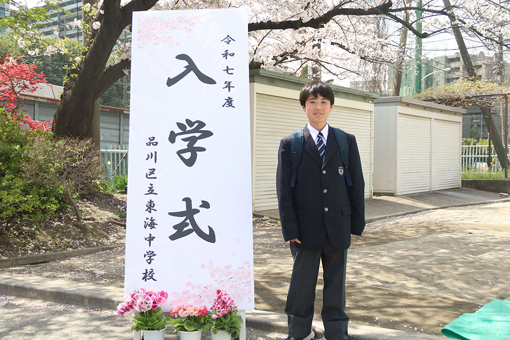 桜の下で写真撮影をする新7年生の画像