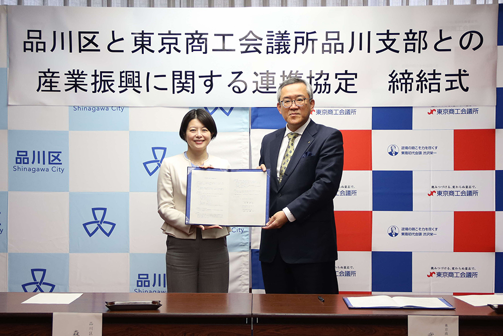 協定書を持ち写真を撮る森澤区長と武田東京商工会議所品川支部会長の画像
