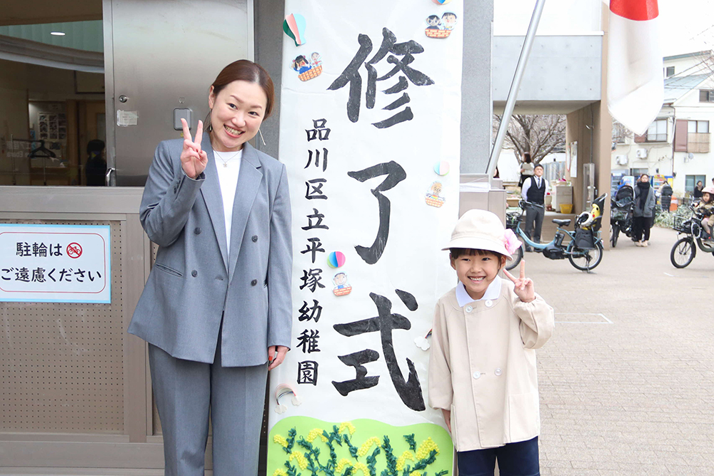 平塚幼稚園の入り口で記念撮影する子どもと保護者の画像