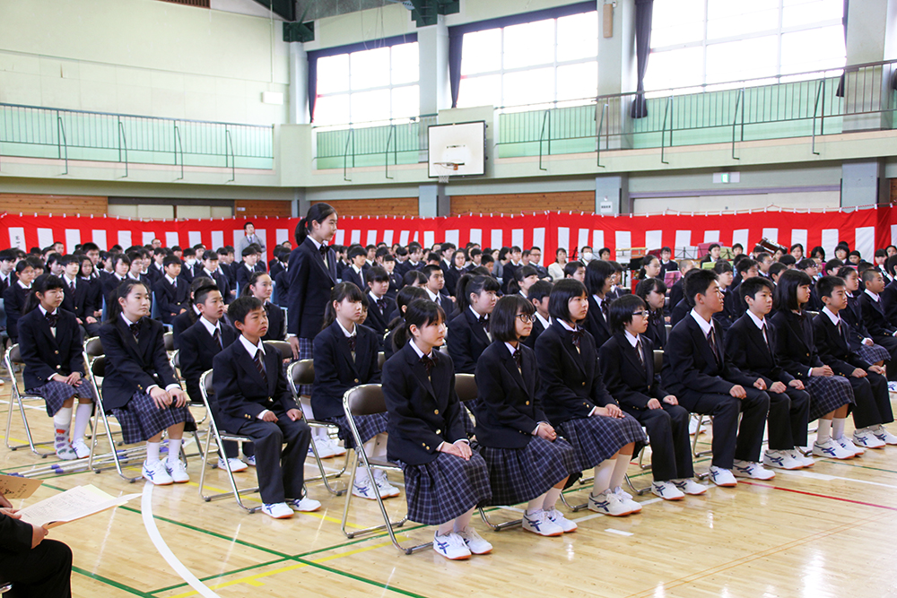 校長先生の話しをきく新入生