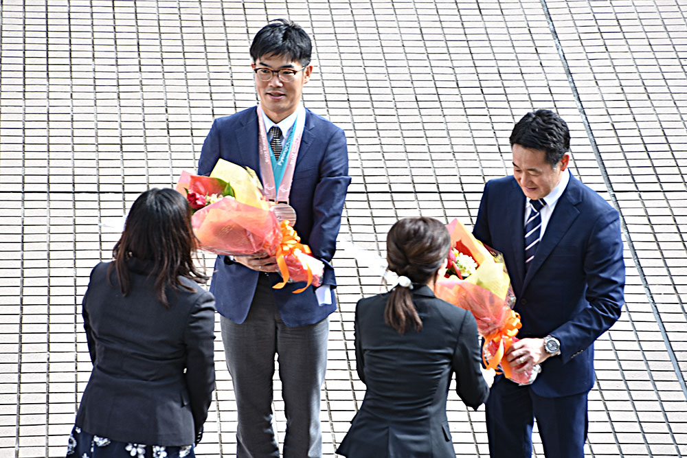 花束を贈られる新田選手と長浜コーチ