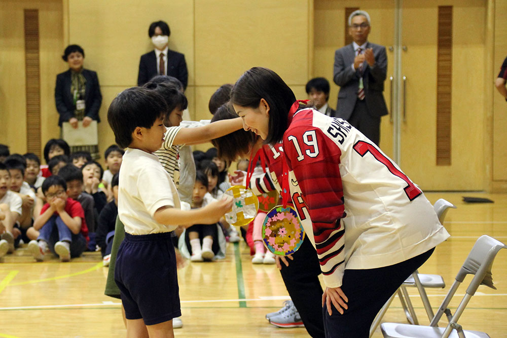 児童から金メダルをプレゼントされる選手たち