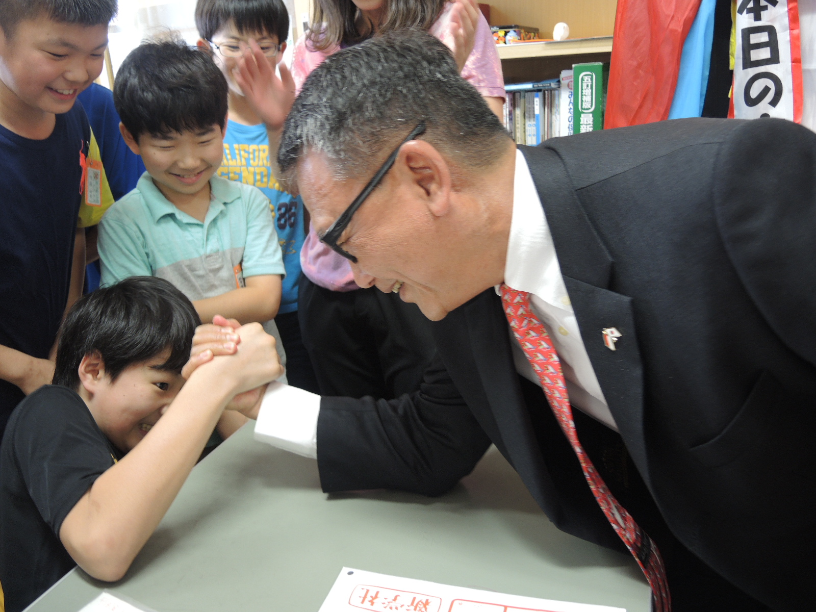 子どもたちと腕相撲をする大使