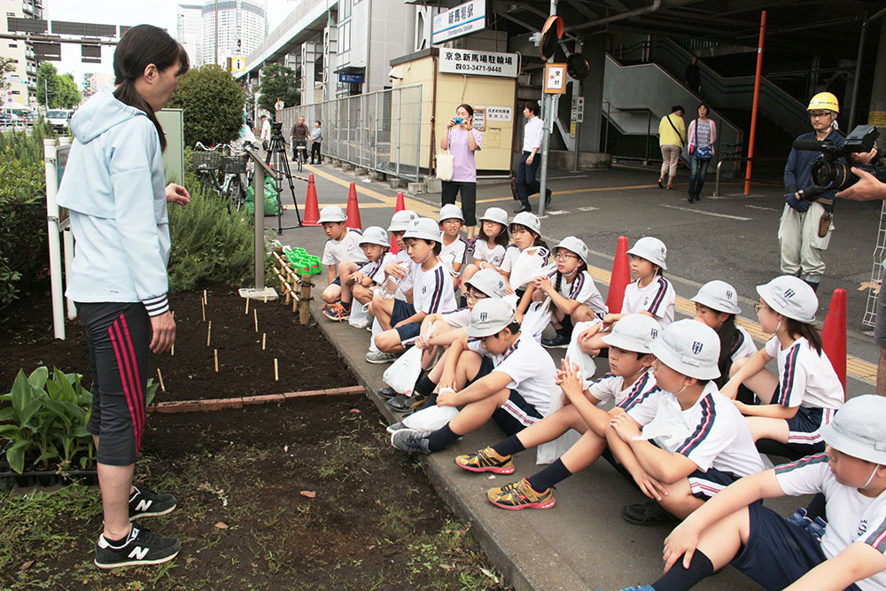 関副校長から「平和の花壇」の由来を聞く児童