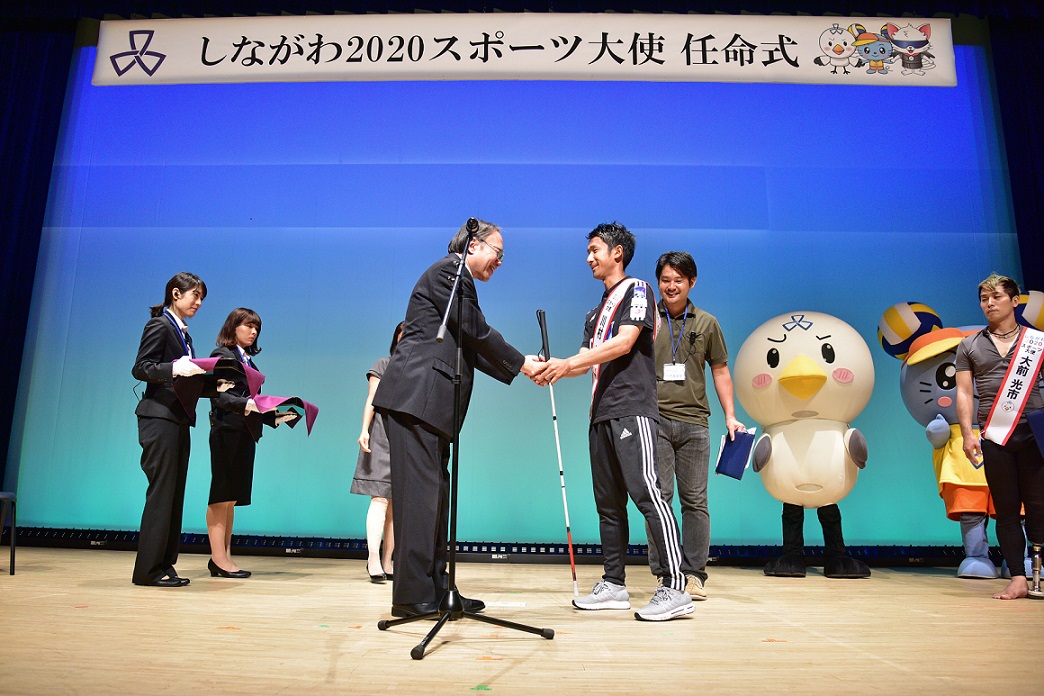 区長と握手する川村さん