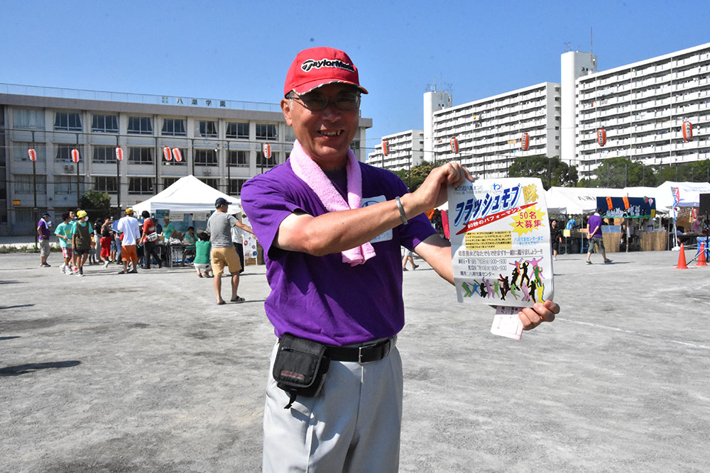 フラッシュモブのっチラシを掲げる丹治会長