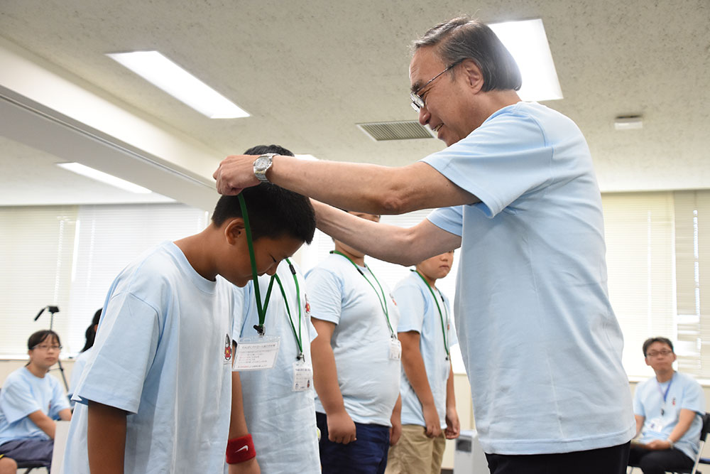 入隊証を濱野区長に首にかけてもらう子どもたち