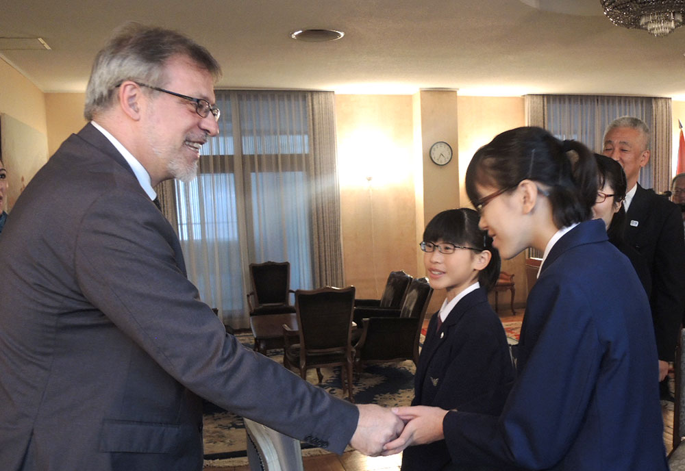 大使と握手する中学生