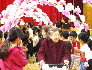 児童の見送りでお花のアーチをくぐり退場