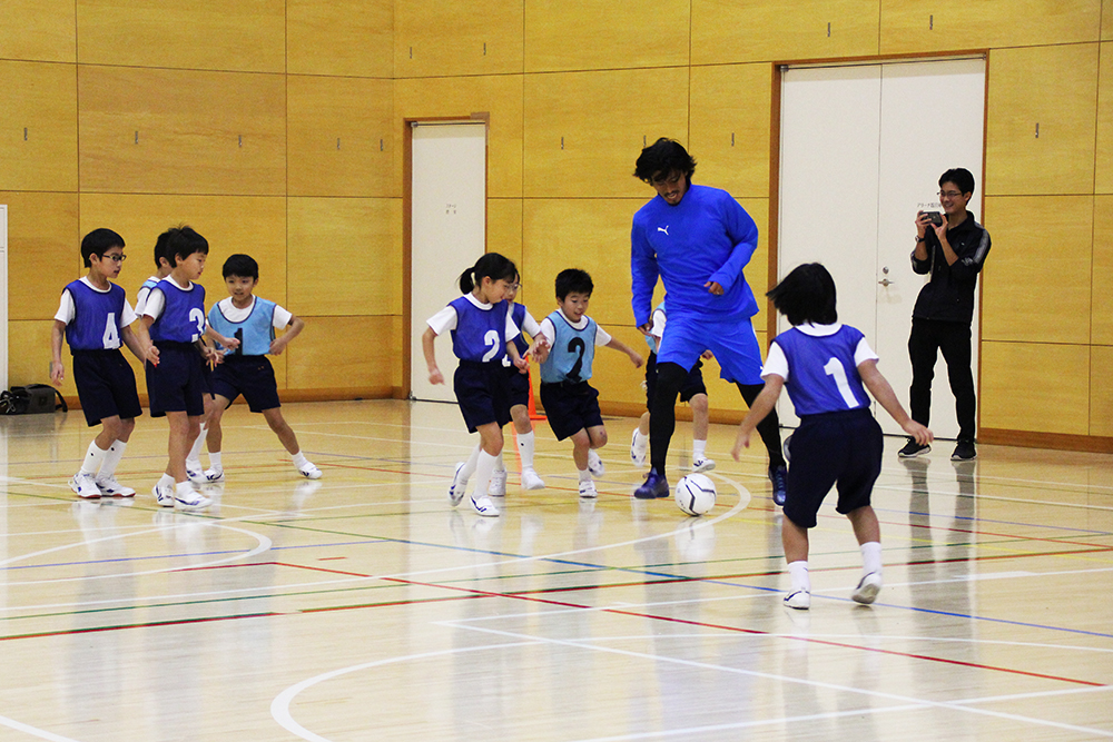 子どもたちとサッカーをする中澤選手