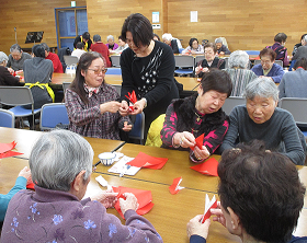 祝い鶴を折る中延地区の参加者