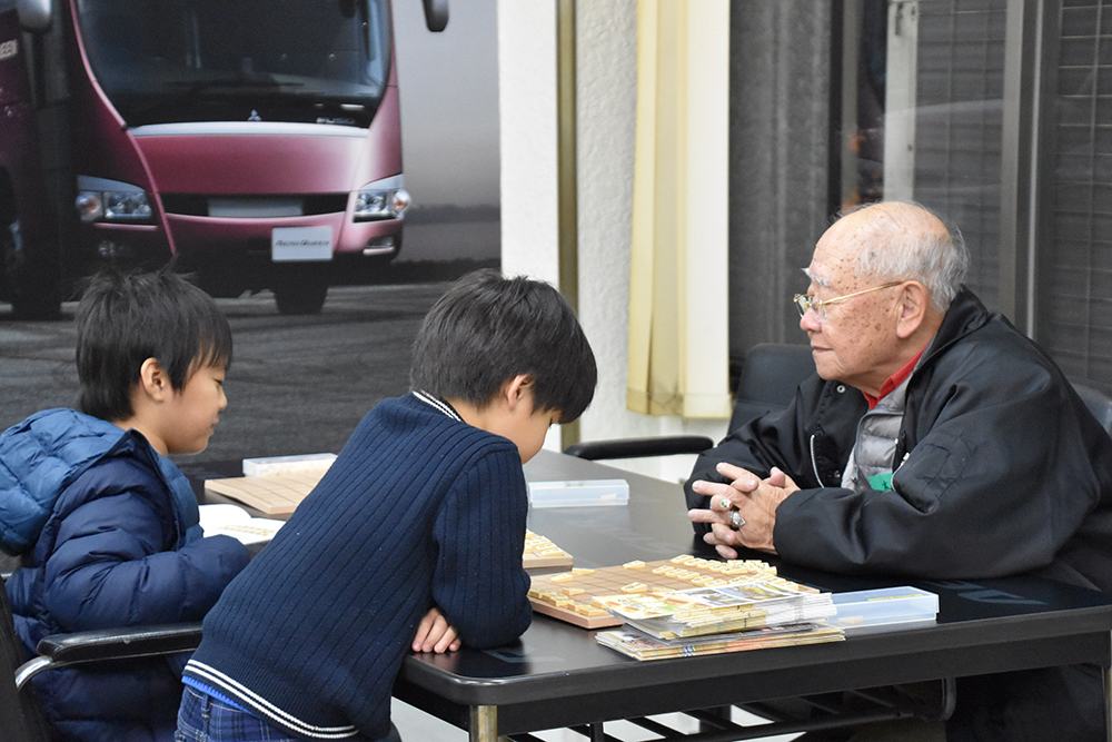 ボランティアと囲碁をする少年