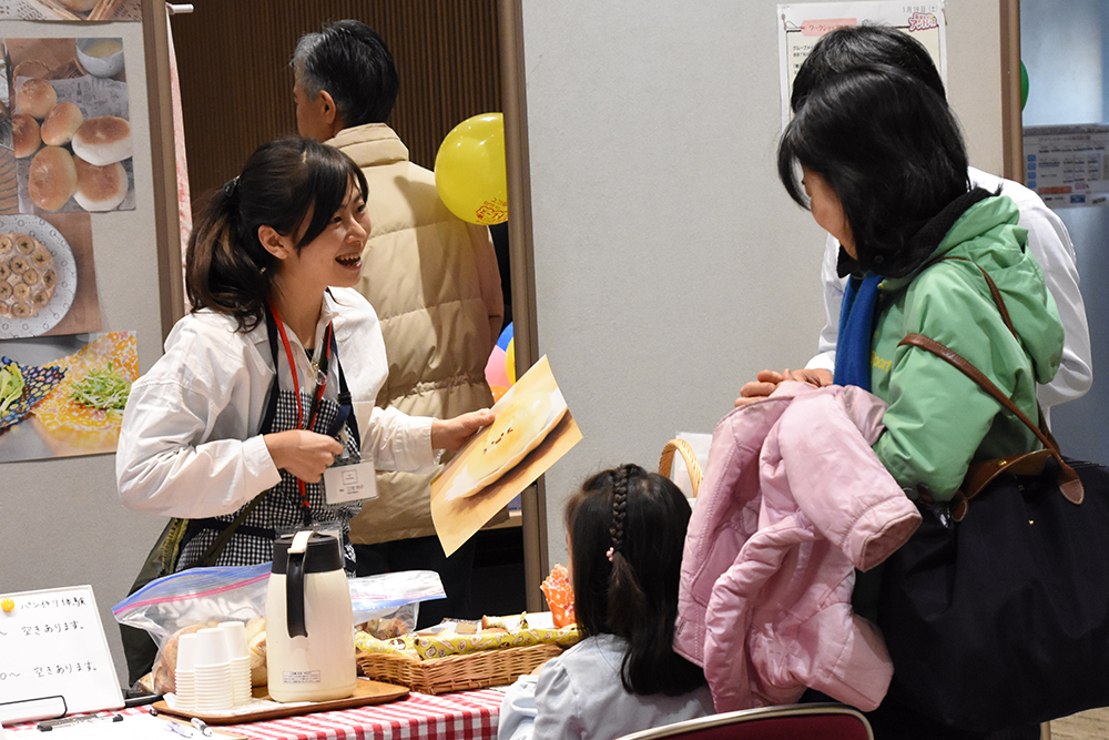 笑顔で対応する女性出展者