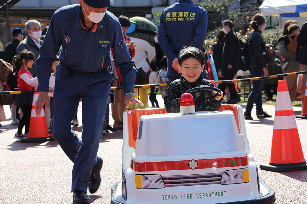 ミニ救急車を満面の笑みで運転する男の子