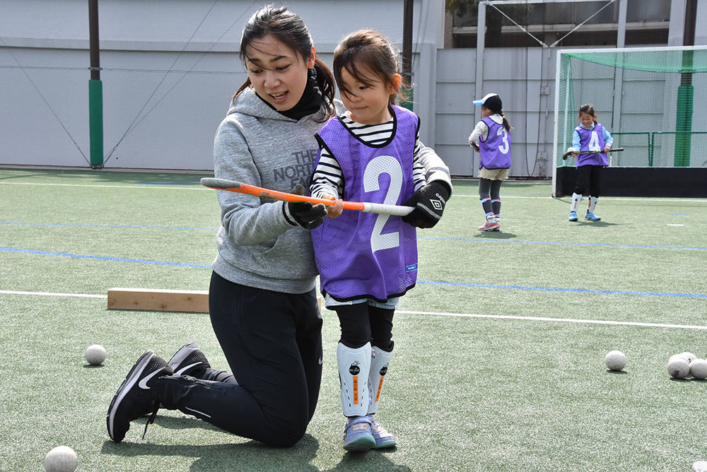 スティックの握り方を教わる女の子