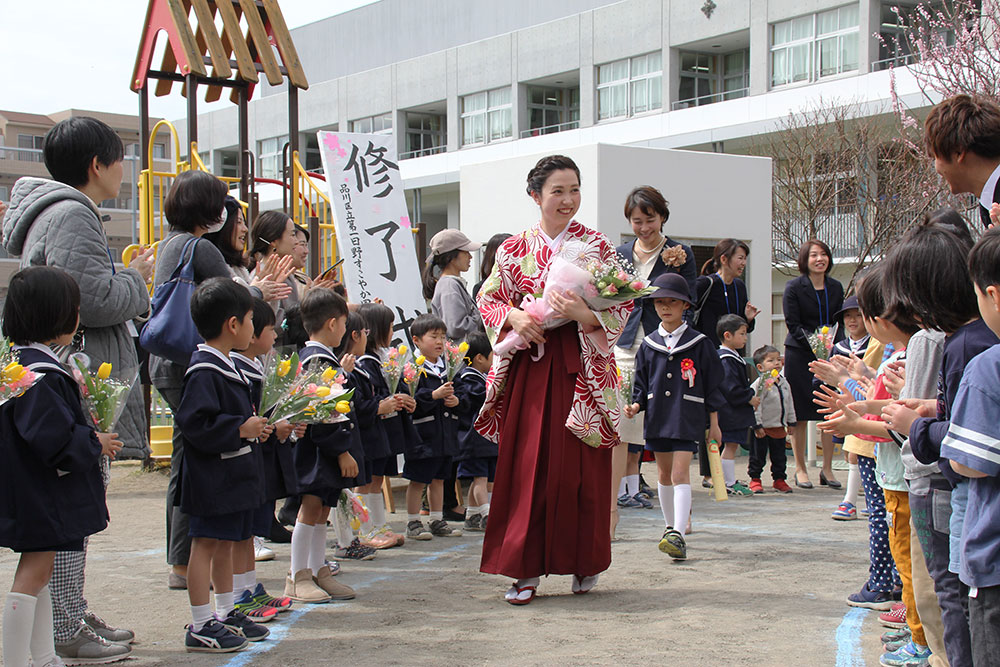 担任の先生に導かれ笑顔で退園する園児