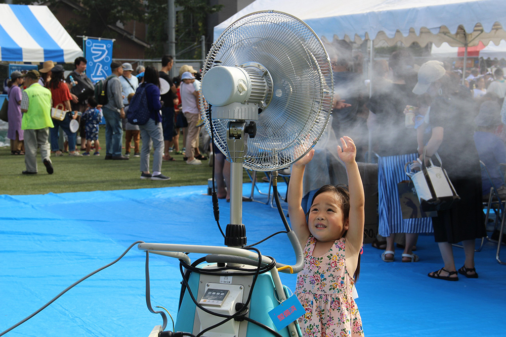 熱中症対策の扇風機を浴びる女の子