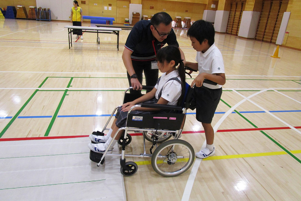 車いすを押す児童